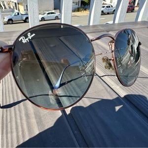 Dark blue hue circular lens raybans. Blue rubber coating on the ear pieces.